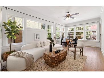 Bright living room featuring large windows, hardwood floors, and a modern sofa at 653 N Highland Ne Ave # 5, Atlanta, GA 30306