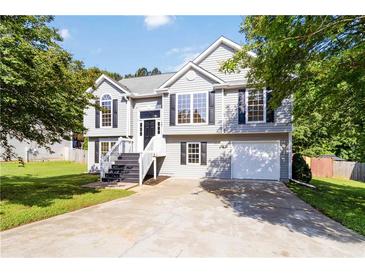 Charming two-story home featuring a well-maintained lawn, garage, and classic architectural details at 7186 Raintree Loop, Jonesboro, GA 30236