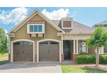 Charming home featuring a brick driveway, two-car garage, and manicured landscaping at 308 Rusty Gate Pass, Woodstock, GA 30189