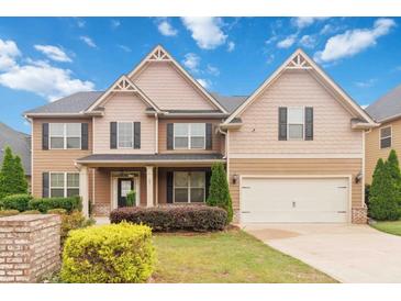 Charming two-story home featuring a two-car garage, landscaped yard, and welcoming front porch at 651 Deer Springs Way, Loganville, GA 30052