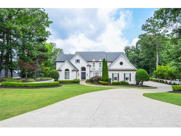 Stately white home with meticulously landscaped lawn and circular driveway at 965 Tiverton Ln, Alpharetta, GA 30022