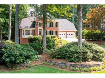 Charming two-story brick home featuring a manicured front yard and an attached two-car garage at 4429 Windsor Oaks Cir, Marietta, GA 30066