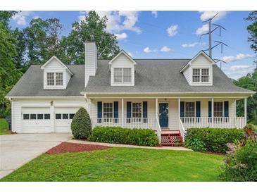 Charming two-story home with a welcoming front porch, two-car garage, and beautiful landscaping at 1624 Glenfield Dr, Lawrenceville, GA 30043