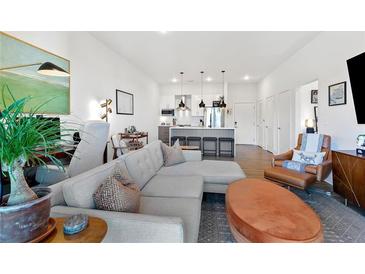 Open living space with modern kitchen, sleek island, and comfortable seating area featuring contemporary decor and hardwood floors at 112 Rogers Street Northeast Ne St # 410, Atlanta, GA 30317