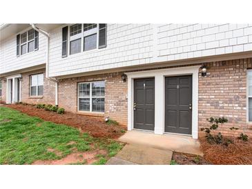 Brick and siding exterior view of townhome with two front doors and well-maintained landscaping at 7 Villa Se Ct, Smyrna, GA 30080