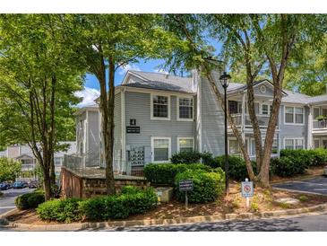 Inviting condo exterior with lush landscaping and a charming, light gray facade and view of the parking area at 1450 Keys Crossing Ne Dr, Brookhaven, GA 30319