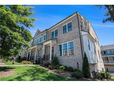 Charming brick townhome with manicured lawn and landscaped entrance in a desirable neighborhood at 710 Elmwood Way, Roswell, GA 30075