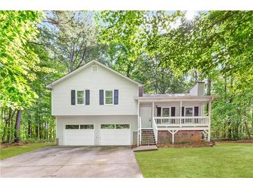 Charming two-story home featuring a welcoming front porch, attached two-car garage, and lush surrounding greenery at 127 Danielle Ct, Villa Rica, GA 30180