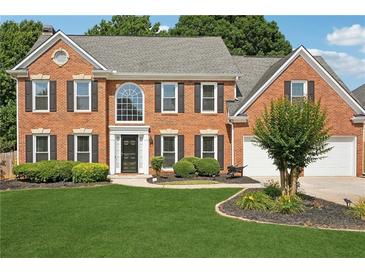 Traditional two-story brick home with a well-manicured lawn and a two car attached garage at 75 Hunters Ct, Dallas, GA 30157