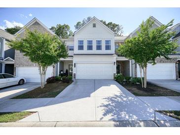 Inviting townhome with a well-maintained front yard and a two-car garage at 128 Madison Bnd, Woodstock, GA 30188