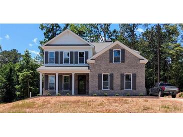 Charming two-story brick home featuring classic architectural details, dark shutters, and a well-manicured front yard at 8239 High Lake Ter, Covington, GA 30014