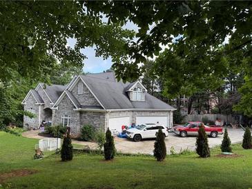 Charming stone home featuring a spacious three-car garage and a lush front lawn at 3393 Childers Ne Rd, Roswell, GA 30075