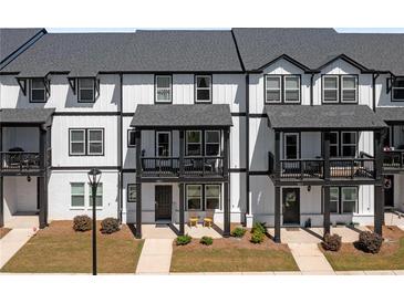 Modern townhouse with black and white trim, front porch, and well-manicured lawn at 823 Mackay Crk, Woodstock, GA 30188