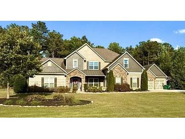 Charming two-story home with stone accents, manicured lawn, and mature trees at 265 Enfield Ln, Mcdonough, GA 30252