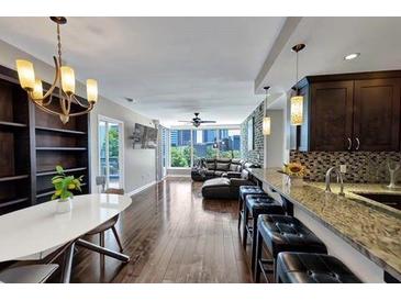 Spacious living room featuring modern decor, a chandelier, hardwood floors, and city views at 3338 Peachtree Ne Rd # 508, Atlanta, GA 30326