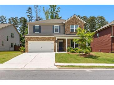 Charming two-story home featuring a brick and gray facade, manicured lawn, and a two-car garage at 510 Cunninghame Ct, Peachtree City, GA 30269