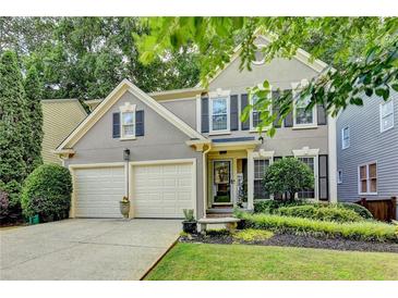 Charming two-story home with a well-manicured front yard and a two-car garage at 10000 Barston Ct, Johns Creek, GA 30022