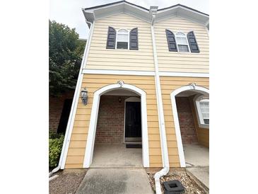 Charming townhouse with brick and siding, featuring a welcoming entrance and black shutters at 602 Summer Pl, Norcross, GA 30071