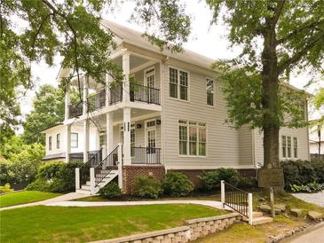 Stately two-story home boasts a charming exterior with double porches, lush landscaping, and mature shade trees at 1764 Defoor Nw Ave, Atlanta, GA 30318
