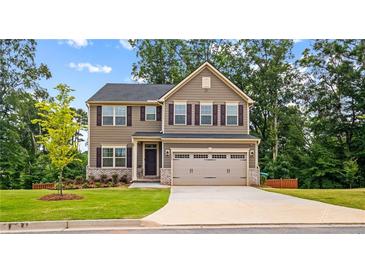 Charming two-story home featuring a well-manicured lawn and a two-car garage at 1049 Climbing Rose Way, Mcdonough, GA 30253
