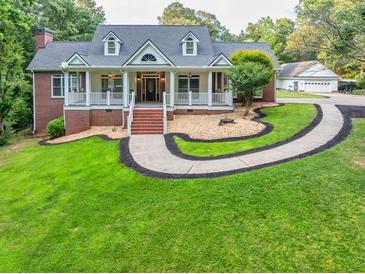 Charming two-story home with a well-manicured lawn, inviting front porch, and a circular driveway at 2230 Ewing Chapel Rd, Dacula, GA 30019
