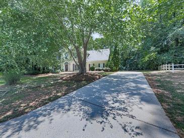 Spacious front yard with mature tree, long driveway and partial view of home at 4601 Ethel Springs Sw Trl, Mableton, GA 30126