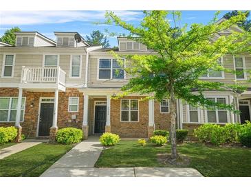 Charming townhome with inviting front yard, stone accents, and covered entrance offers a welcoming curb appeal at 2348 Bigwood Trl, Atlanta, GA 30349
