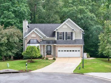 Charming two-story home featuring brick accents, a well-manicured lawn, and a driveway leading to an attached garage at 4000 Mcpherson Drive, Acworth, GA 30101