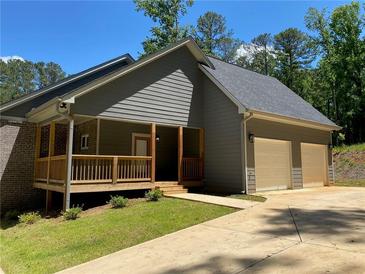Beautiful home with gray siding, brick accents, 2-car garage, and inviting front porch at 5950 Lynfield Dr, Atlanta, GA 30349