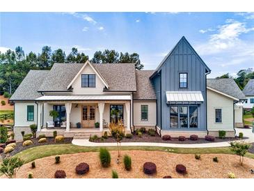 Stunning two-story home featuring a covered porch, meticulous landscaping, and modern farmhouse architectural design at 00 Memory Ln, Canton, GA 30115