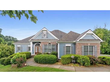 Charming one story home with manicured landscaping, and a brick and light blue facade at 300 Towne Overlook Cir, Canton, GA 30114