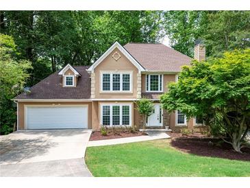 Charming two-story home featuring a well-manicured lawn, two-car garage, and a welcoming stone-accented entrance at 313 Clubhouse Nw Ct, Kennesaw, GA 30144