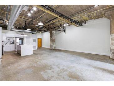 Bright living room featuring modern kitchen, industrial ceiling, and concrete floors at 505 Whitehall Sw St # 102, Atlanta, GA 30303