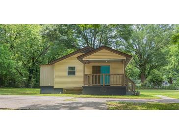 Charming single-story home with a cozy front porch and a bright blue front door at 525 Baker Nw Cir, Atlanta, GA 30318