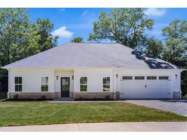 Charming single-story home with a white exterior, a gray roof, and an attached two-car garage at 614 Glendale Rd, Scottdale, GA 30079