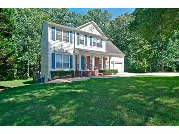 Two-story home with blue shutters, covered porch, and a well-manicured lawn at 809 Longbranch Ln, Douglasville, GA 30134