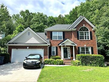 Charming brick home with a well-manicured lawn, a two-car garage and manicured front yard at 627 Arbour Way, Suwanee, GA 30024