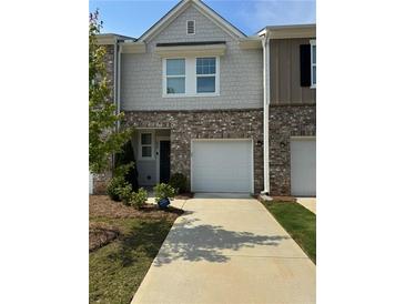 Charming townhome exterior with a well-manicured lawn and attached one car garage and brick and siding details at 536 Magnolia Cir # 116, Palmetto, GA 30268