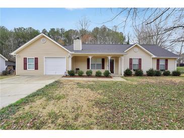 Charming single-story home with a well-manicured lawn and a cozy front porch at 130 Nicki Ct, Hampton, GA 30228