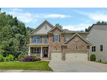 Traditional two-story home with a brick and stone facade and a well-manicured lawn with mature trees in the background at 204 Starwood Ct, Acworth, GA 30102