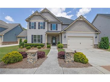 Charming two-story home with manicured lawn, stone accents, and inviting entryway at 675 Mallard Cv, Loganville, GA 30052