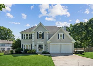 Charming two-story home with a well-manicured lawn and attached two-car garage at 7025 Coffield Ct, Cumming, GA 30041
