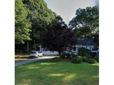Charming single-story home with a lush front yard and a convenient private driveway at 60 Parkman Trl, Covington, GA 30016