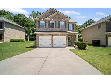 Charming brick two-story home with a well-manicured lawn and a two-car garage at 5575 Hedge Brook Dr, Cumming, GA 30028