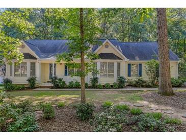 Charming ranch home with beautiful landscaping, blue shutters, and a welcoming entrance at 360 N Oakland Circle, Mcdonough, GA 30253