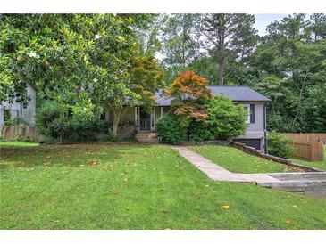 Charming single-Gathering home featuring lush front lawn, mature trees, and a welcoming exterior at 1837 Lochlomand Se Ln, Smyrna, GA 30080