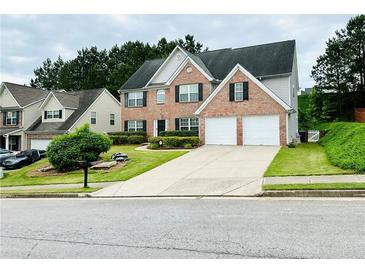 Traditional two-story brick home featuring a two-car garage and well-manicured lawn at 665 Roxford Ln, Buford, GA 30518