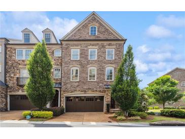 Beautiful brick townhome with manicured landscaping and attached garage at 502 Abbington River Ln, Atlanta, GA 30339