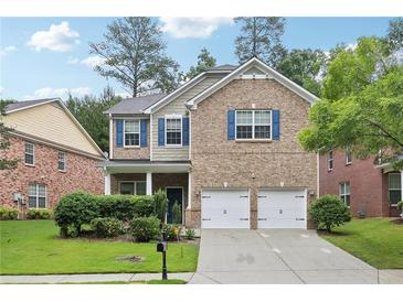 Charming two-story home with brick facade, blue shutters, two-car garage and a well-manicured lawn at 5937 Sharp Se Dr, Mableton, GA 30126