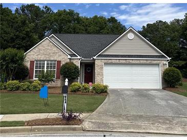 Charming single-story home featuring brick facade, landscaped yard, and a two-car garage at 964 Village View Cir, Loganville, GA 30052